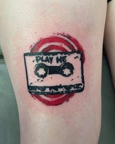 a tattoo with an old school cassette tape on it's leg that says play me