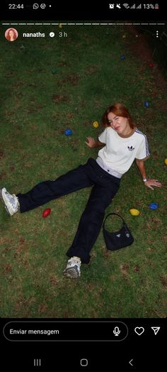 a woman laying in the grass with her hand on her hip while wearing adidas shoes