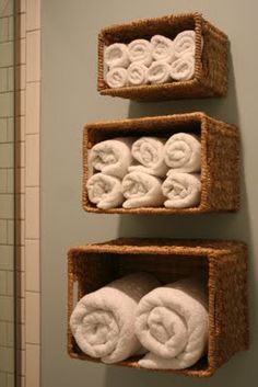 three baskets with towels hanging on the wall