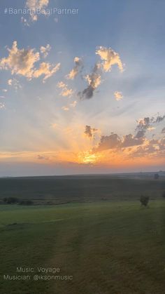 the sun is setting over an open field