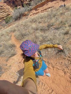 a woman is taking a selfie while hiking in the desert with her backpack on