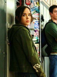 two young people standing in front of a locker with stickers on it and looking at the camera