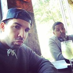 two men sitting at a table with drinks in front of them