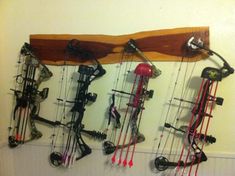 a wall mounted with lots of different types of archery bows and arrows hanging on it