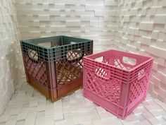 two pink and green crates sitting next to each other on a white tiled floor in front of a wall