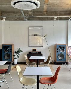 a room with chairs, tables and speakers in it