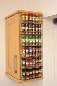 a wooden spice rack with spices and condiments hanging on it's side