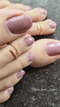 a woman's hands with pink manies and gold rings