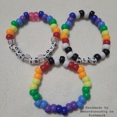 two bracelets with words on them are made out of plastic beads and bead