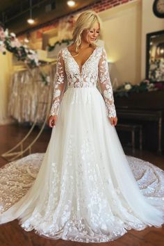 a woman in a white wedding dress standing on a wooden floor