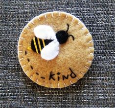 a pin with a bee sitting on top of it's back and the words king written in black ink