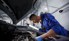 a man working on an engine in a garage