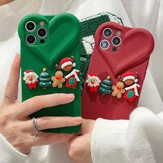 two cases with christmas decorations on them are being held up by someone's hand