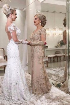 two women standing in front of a mirror and one is wearing a dress with flowers on it