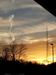 the sun is setting with some clouds in the sky