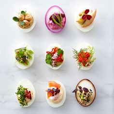 several different types of appetizers are arranged on a white surface