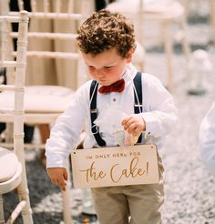 a young boy holding a sign that says i'm only here for the cake