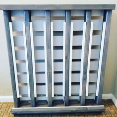 an old book shelf is sitting on the floor in front of a white wall and tiled floor