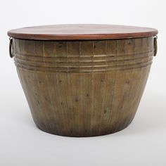 a large wooden bucket with handles on the top and bottom, sitting in front of a white background