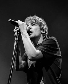 a man holding a microphone on top of a stage