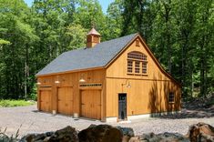 a large wooden building sitting in the middle of a forest filled with trees and rocks