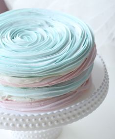 a stack of pastel blue and pink cake icing