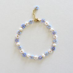 Blue flower bracelet with pearls Daisy flower bracelet for women  Freshwater pearl bracelet Gold Filled Jewelry Dainty Handmade Bracelet 24k gold plated brass chain and clasp. To determine your exact wrist/ankle size, get a tape measure! The bracelet is made of light blue and white Czech beads size 10/0 (about 2mm diameter), freshwater pearls measuring about 4mm and a 24k gold plated clasp and extension chain. Cute and delicate daisy bracelet with pearls will add a light touch to your casual and holiday outfits! Lobster clasp and extender for length adjustment and easy removal. Jewerly Beads Bracelets, Jewelry Ideas Handmade, Matching Pearl Bracelets, Diy Bracelets Pearl, Blue Flower Jewellery, Seed Glass Bead Bracelet, Cute Beaded Jewelry Ideas, Self Made Bracelets, Bracelet Patterns Beads