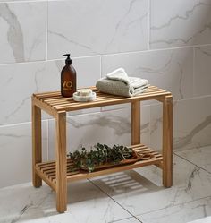 a bathroom with marble tiles and a wooden shelf on the floor next to a bathtub