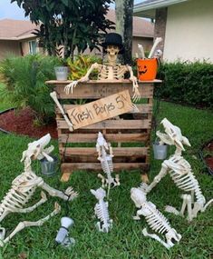 halloween decorations made out of pallets in the grass with skeletons and pumpkins on them