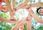 a group of people standing in a circle with their hands on top of each other