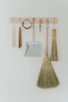 brooms and other tools hanging on a wall