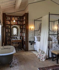 a bathroom with a tub, bookshelf and table in it's center