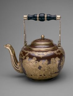 an antique teapot with gold decoration on it