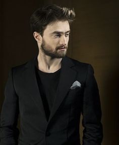 a man with a beard wearing a black suit