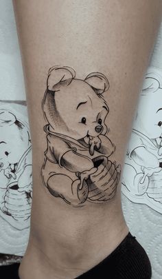 a black and white drawing of a teddy bear on the side of a woman's leg