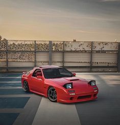 a red sports car parked on top of a parking lot