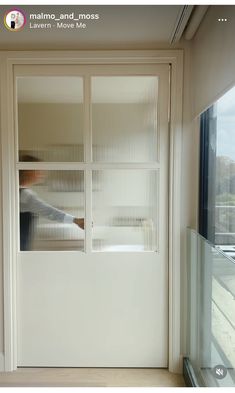 a person standing in front of a white door with blinds on the outside and inside