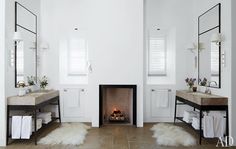 a white bathroom with two sinks and a fire place