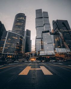 an empty city street with tall buildings in the background