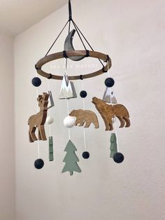 a wooden mobile with animals and trees hanging from it