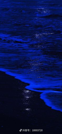 the moon shines brightly in the dark blue sky over the water at the beach