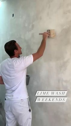 a man is painting the wall with white paint