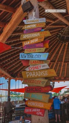 many signs are hanging from the roof of a building