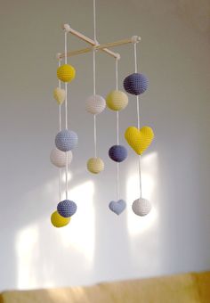a crocheted mobile with hearts hanging from it's sides in a room