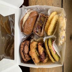 a box filled with assorted pastries on top of a wooden table