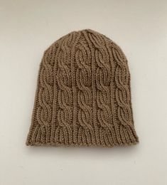 a brown knitted hat on a white surface