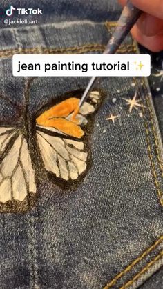 someone is painting a butterfly on their jeans