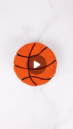 an orange basketball on a white surface with a play button in the bottom right corner
