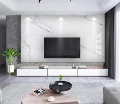 a modern living room with marble walls and white furniture, including a large flat screen tv on the wall