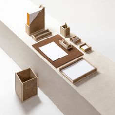 an assortment of stationery items displayed on a white surface with two empty wooden boxes